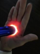 Flashlight pressed to a palm