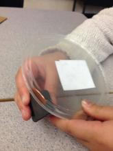 A plastic lid with a ridge at the edge makes the penny flip on its side